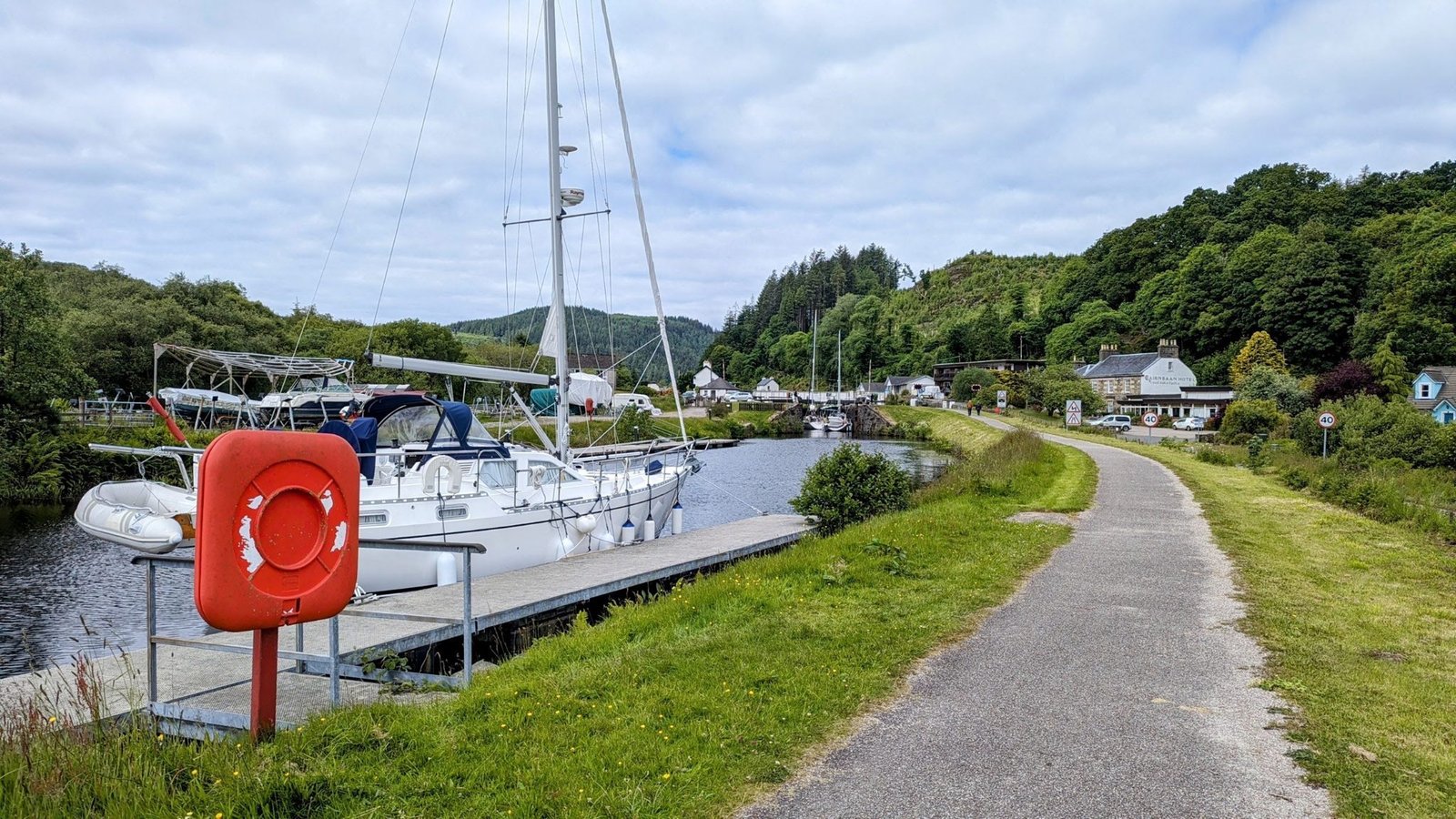 Yachts moored along the Crinan Canal at Cairnbaan with the towpath alongside.