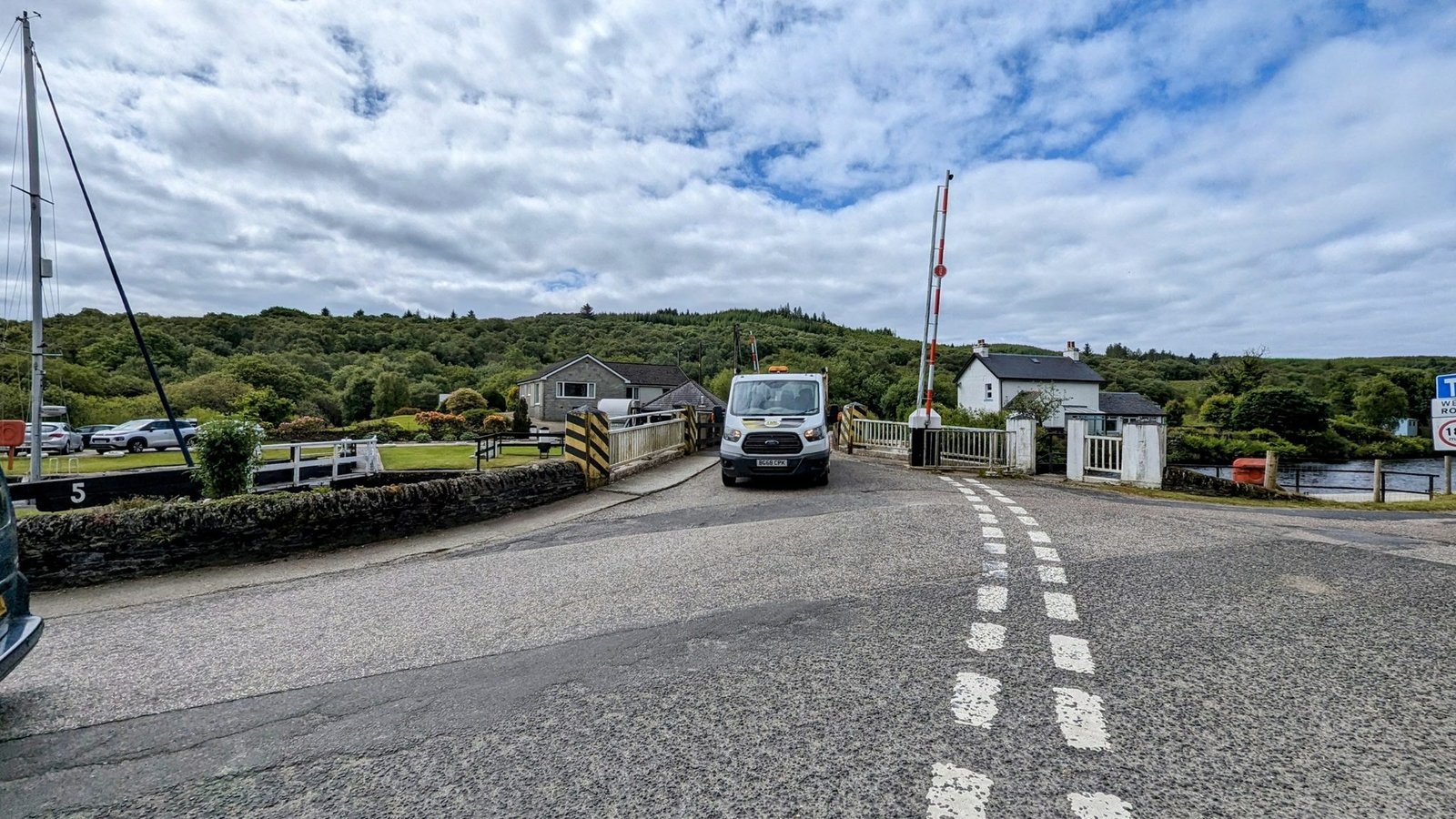 A road swing bridge across the Crinan Canal at Cairnbaan with a van crossing.