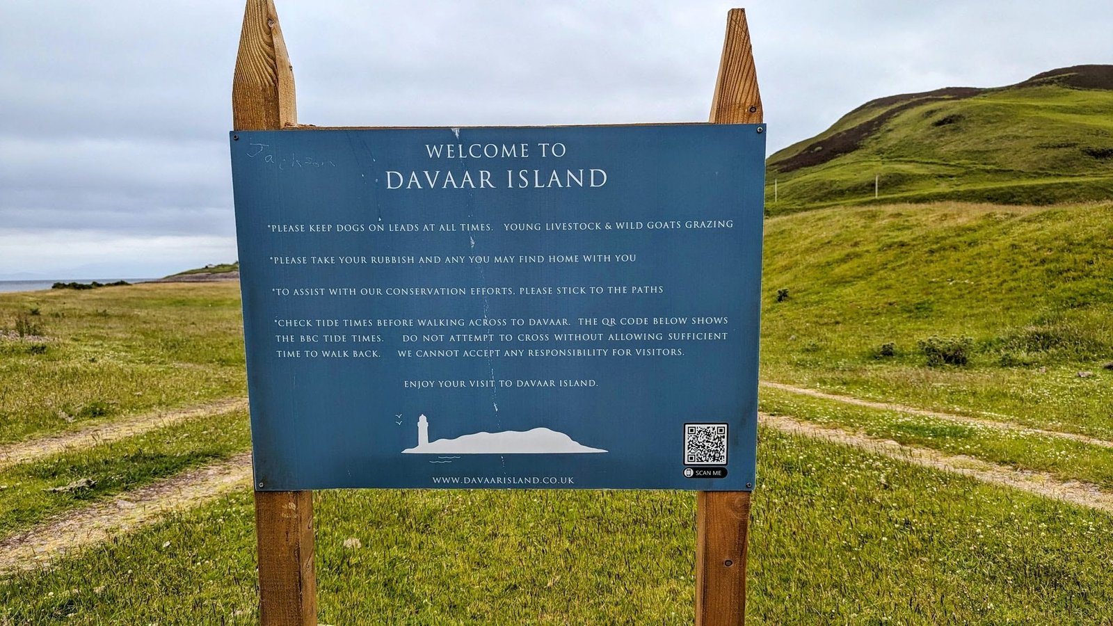 The 'Welcome to Davaar Island' sign asking visitors to check tide times, keep dogs on leads, and respect the wild goats and grazing livestock.