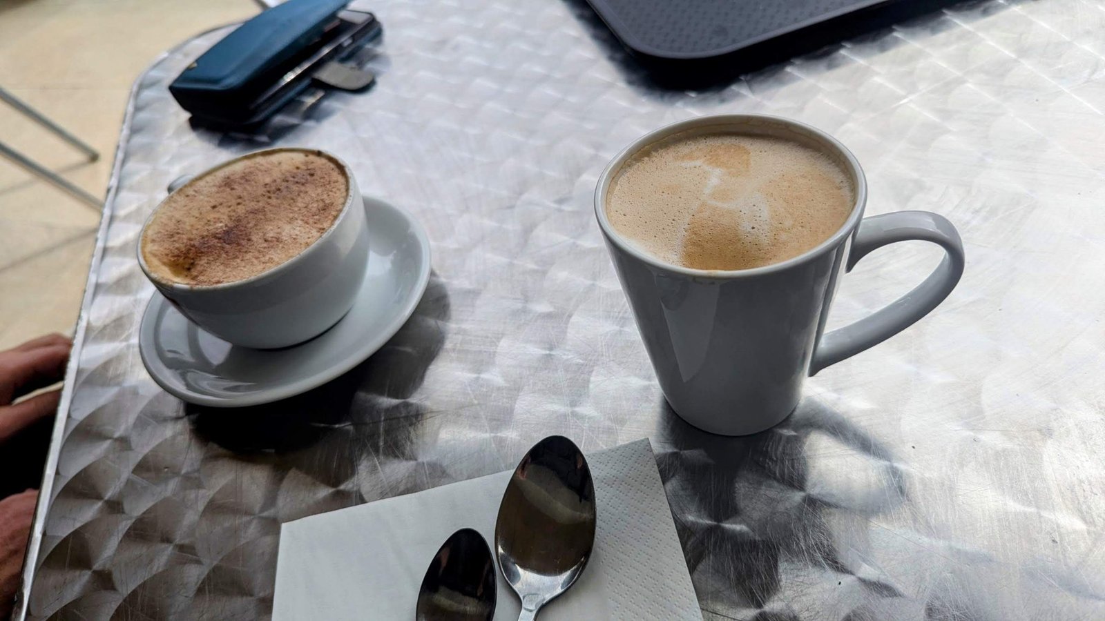 A cappuccino and a latte on a café table in Dunfermline.