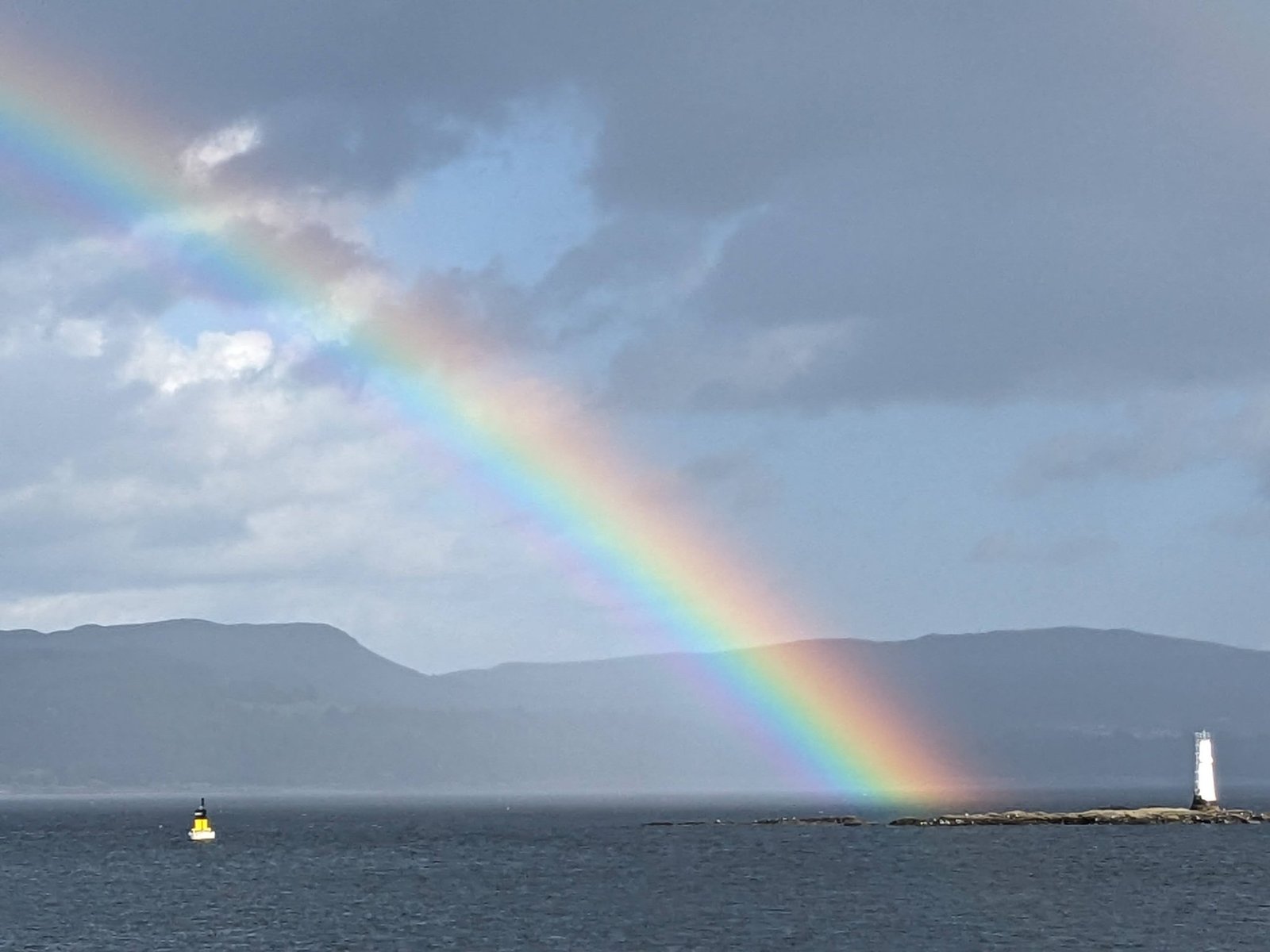A vivid rainbow arcing down into the Firth of Clyde off Dunoon, a beacon in the water below.