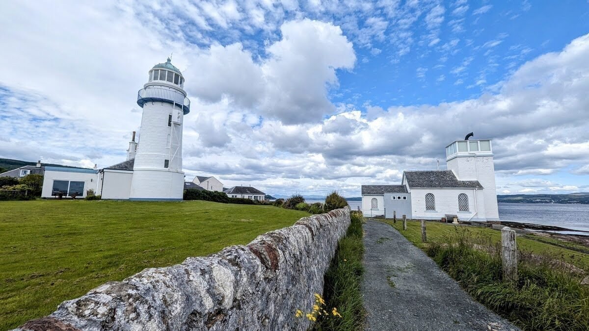 The white Toward Point lighthouse and keeper's cottage on the southern tip of the Cowal peninsula.