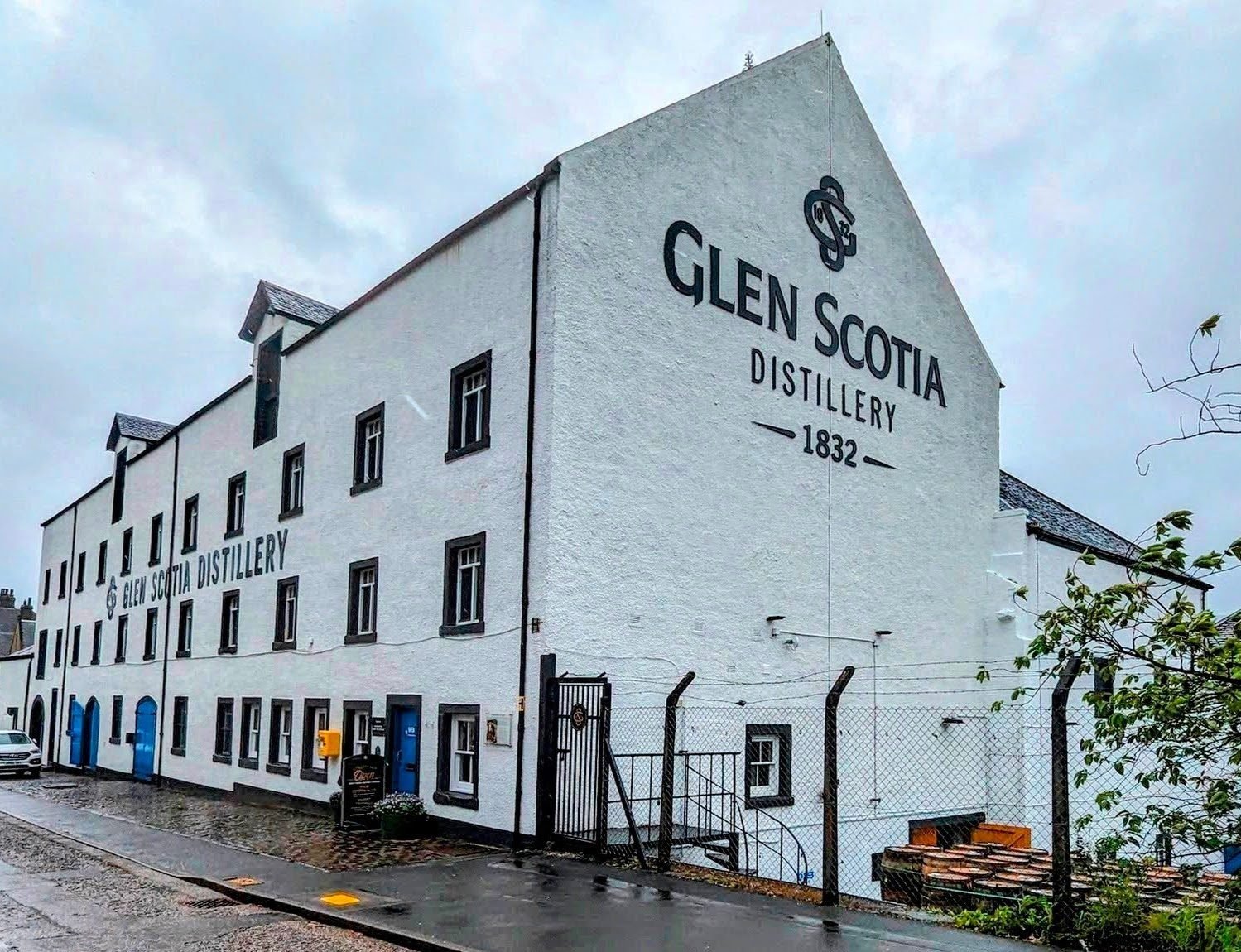 A shop shelf of Glen Scotia 15 Year Old single malt boxes beside a Scottish Whisky Awards 2023 Gold Medal display.