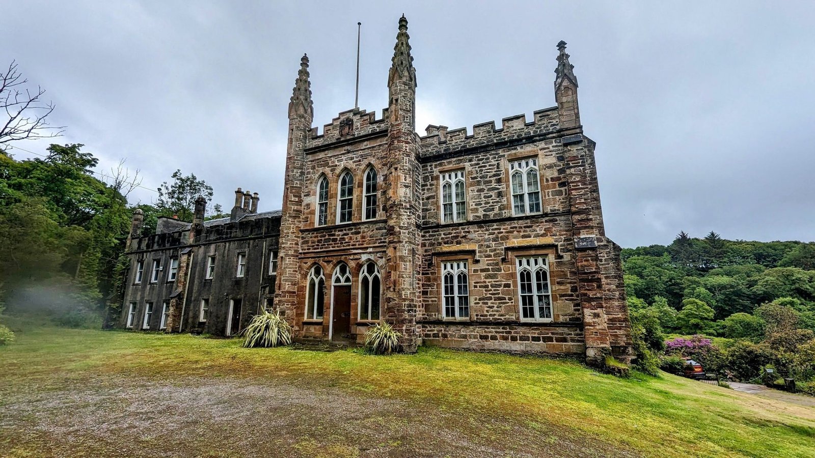 The Gothic entrance tower of Glenbarr Abbey with tall pinnacles, a pointed-arch doorway and traceried windows.
