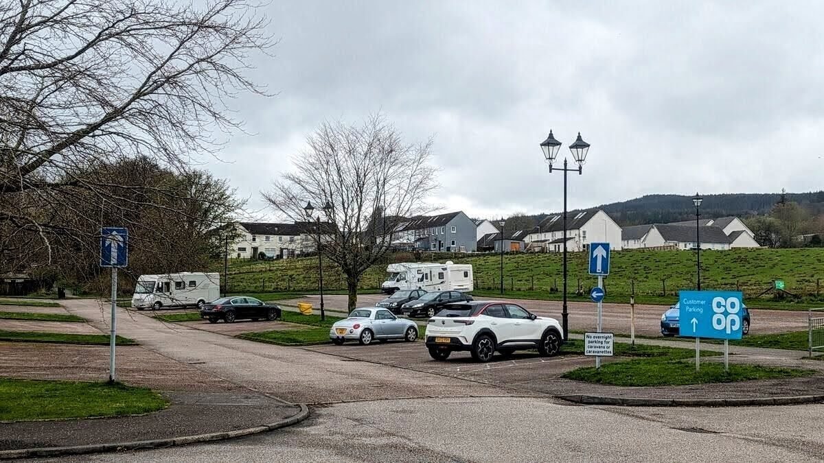 Motorhomes and cars parked in the loch-side car park at Inveraray beside the Co-op.