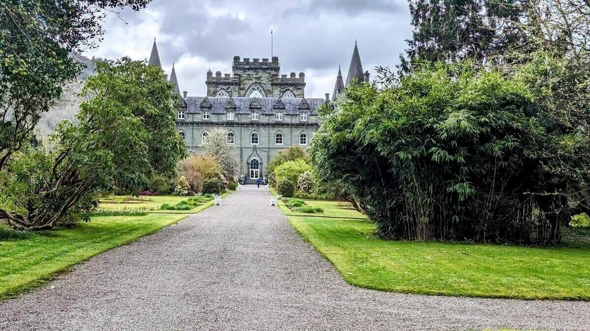 The garden approach to Inveraray Castle, a broad path between lawns and shrubs leading to the turreted castle.