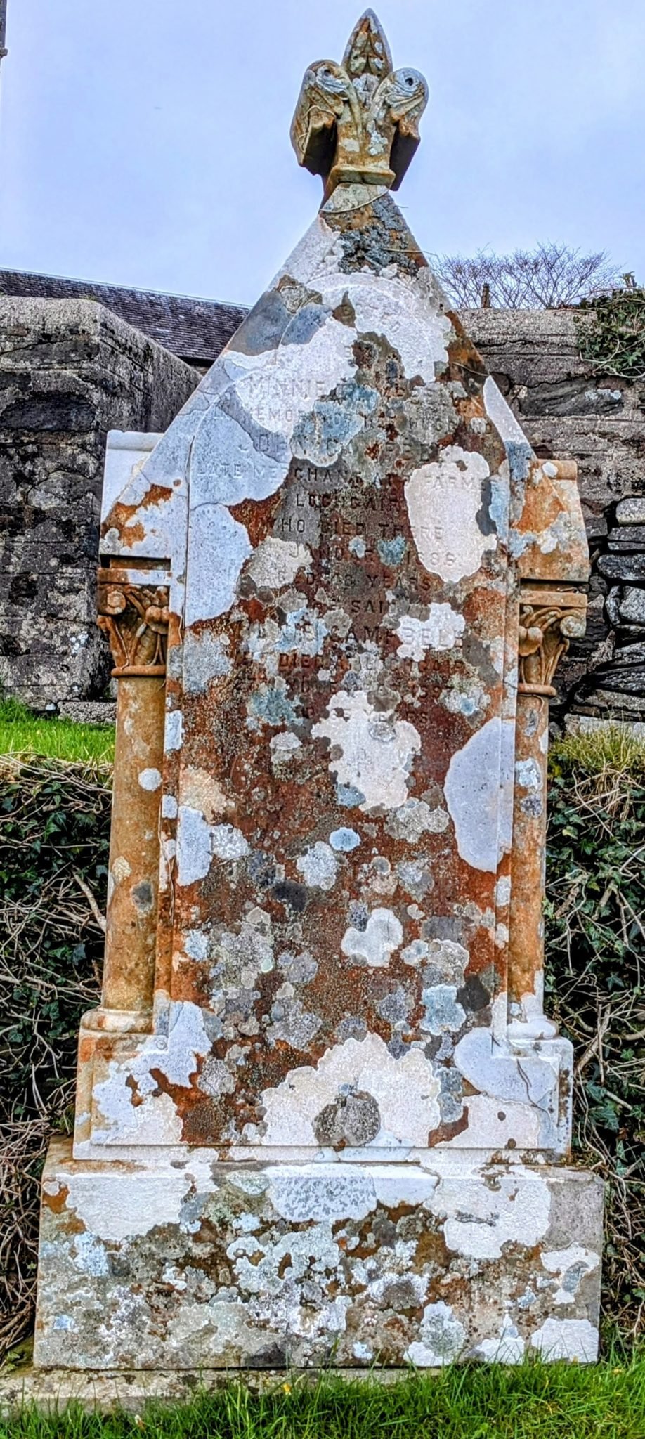 An ornate, lichen-covered carved medieval cross-slab standing in Kilmartin churchyard.