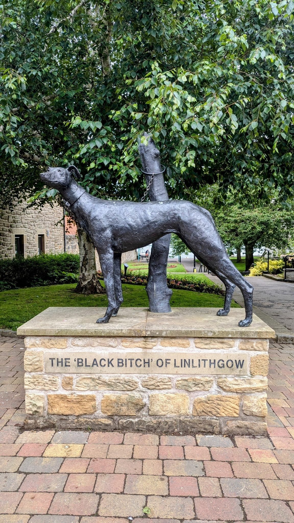A bronze statue of a greyhound on a plinth reading 'The Black Bitch of Linlithgow'.