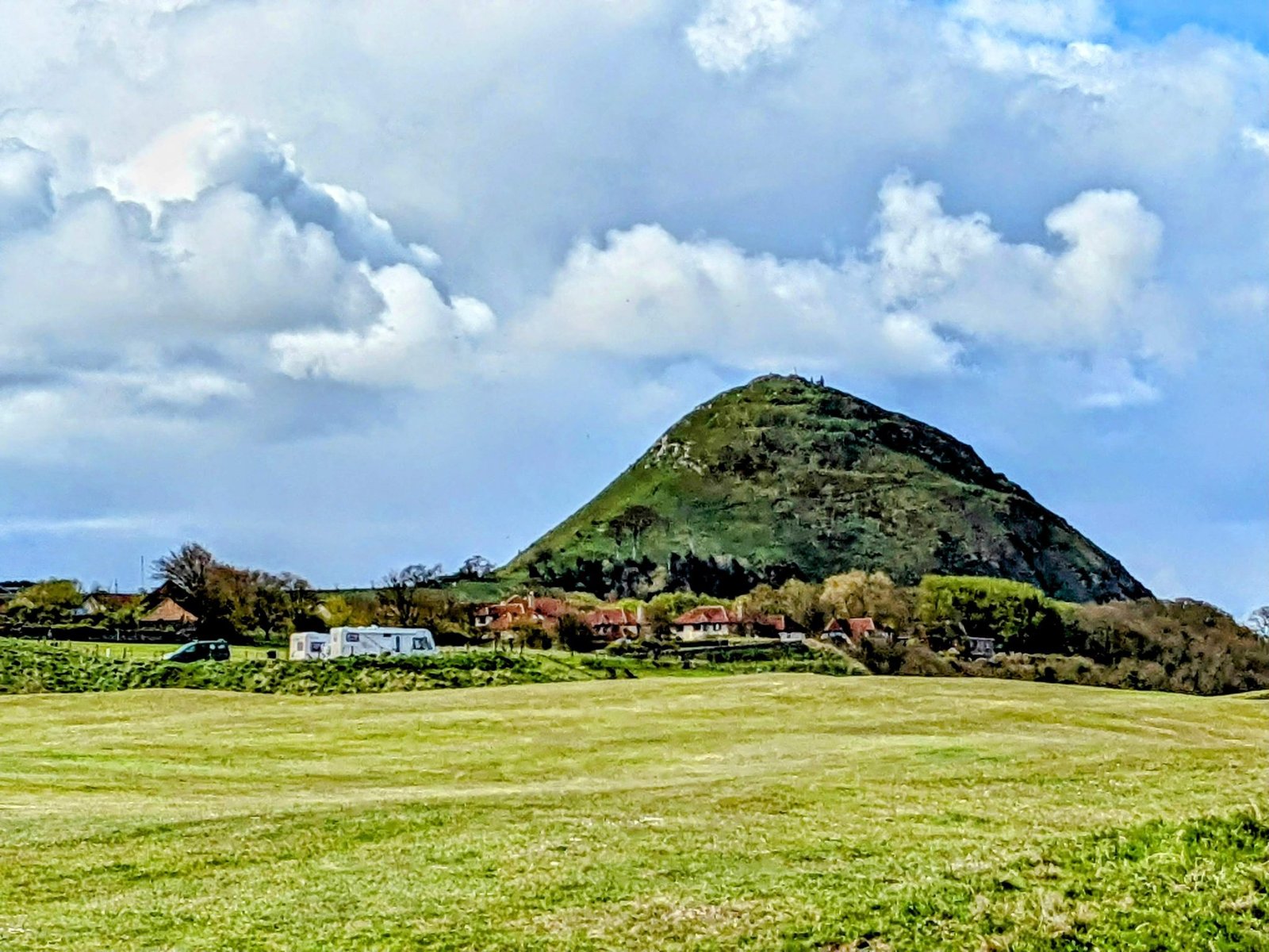 North Berwick Law, the conical volcanic hill rising behind the town, with golf-course greens and houses at its foot.