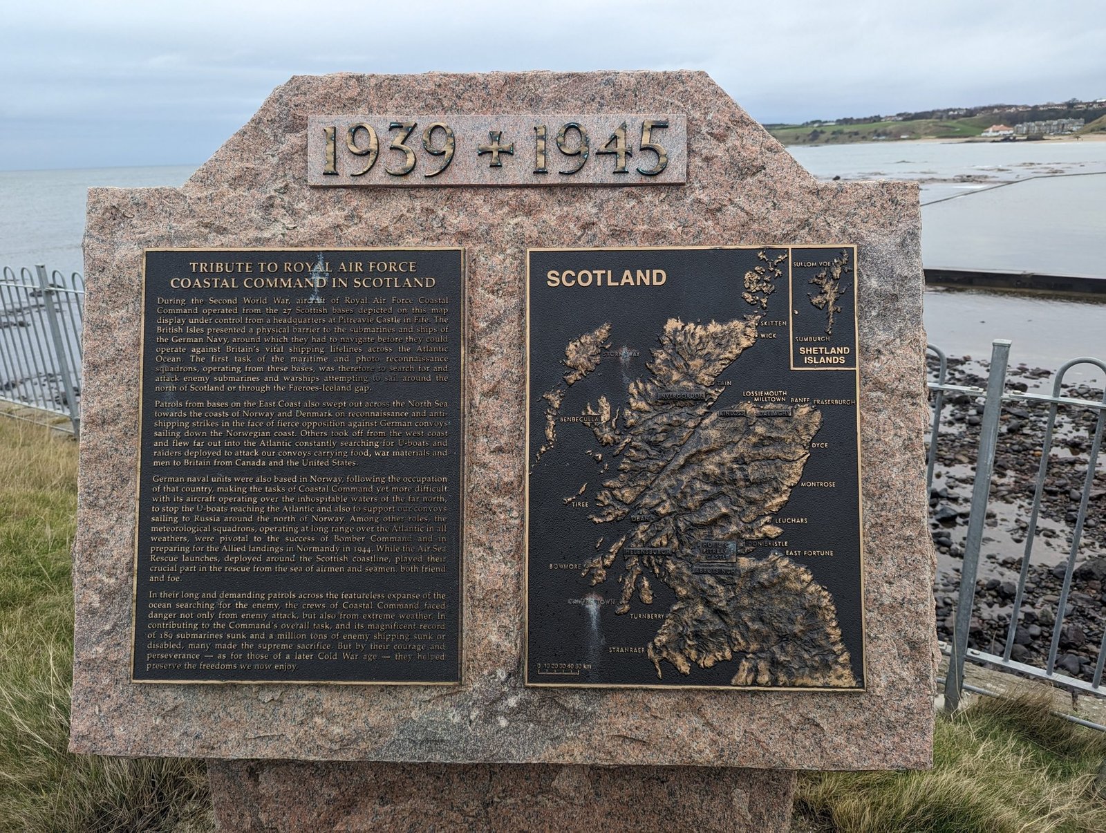 Granite memorial inscribed '1939 1945' with a bronze relief map of Scotland, a tribute to RAF Coastal Command, on the North Berwick shore.