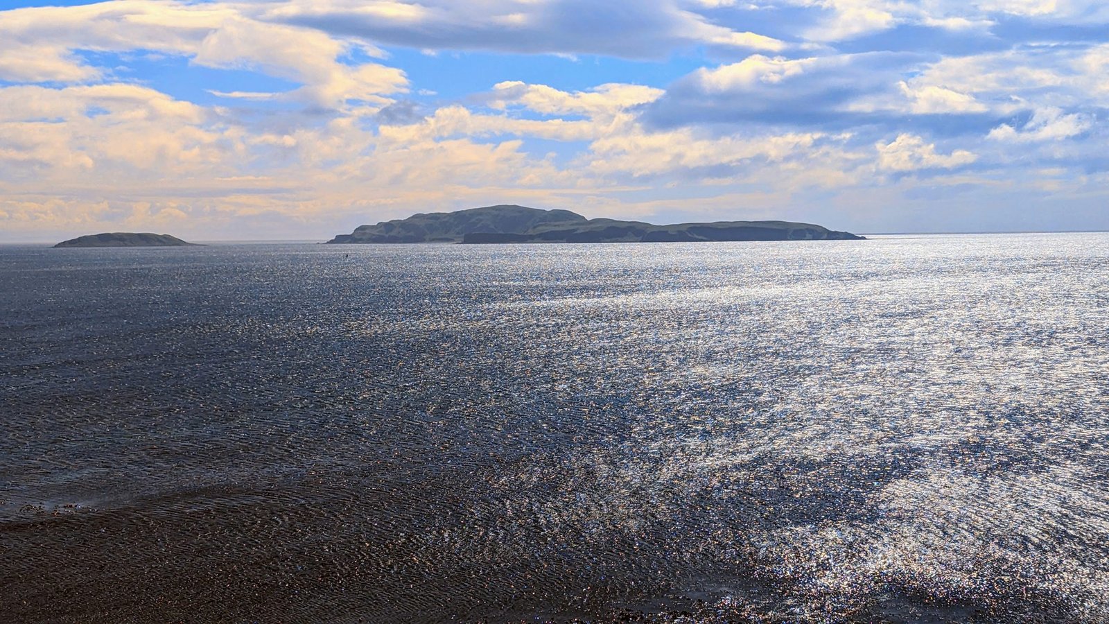 The calm sea off Southend looking out to Sanda Island on the horizon.