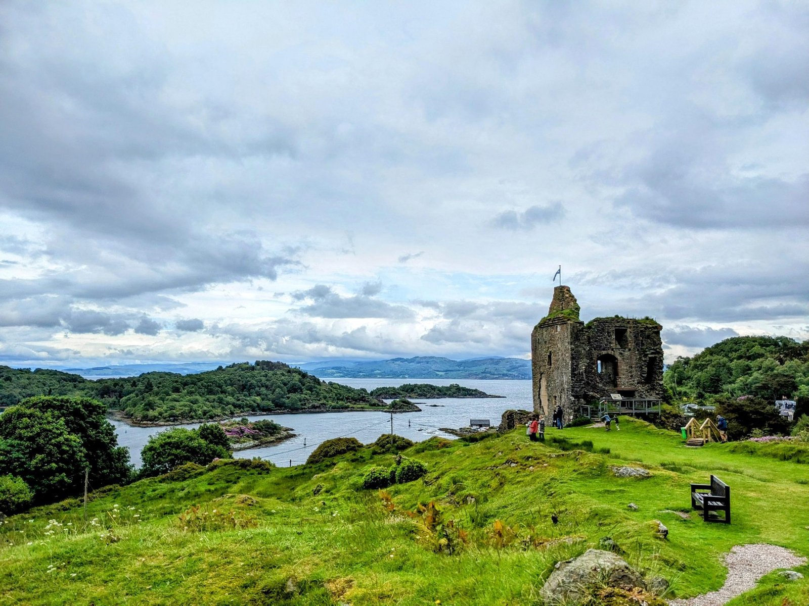 Tarbert Castle ruin on its hill with Loch Fyne and scattered islands stretching behind.