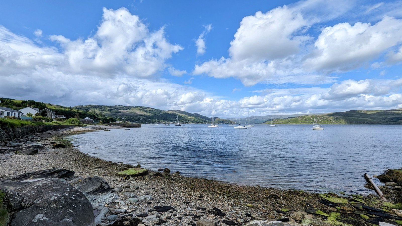Approaching the Cowal shore at Portavadie from the Tarbert ferry, houses along a quiet bay.