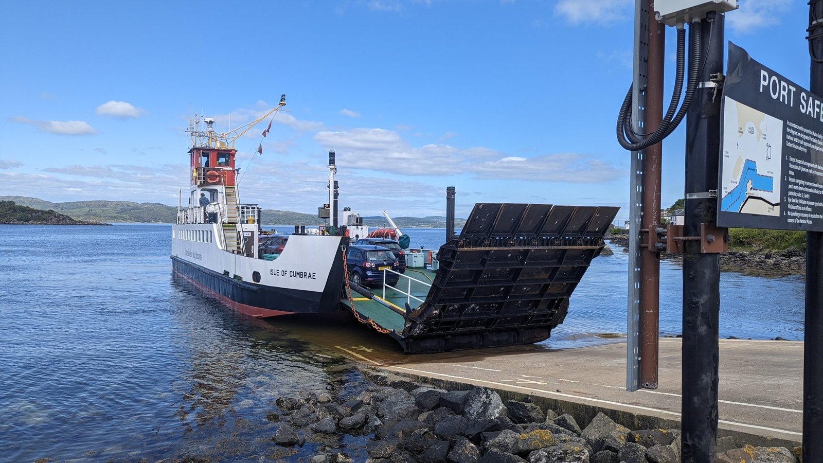 The Isle of Cumbrae ferry at the Tarbert slipway with its ramp down for loading, the Portavadie sign alongside.