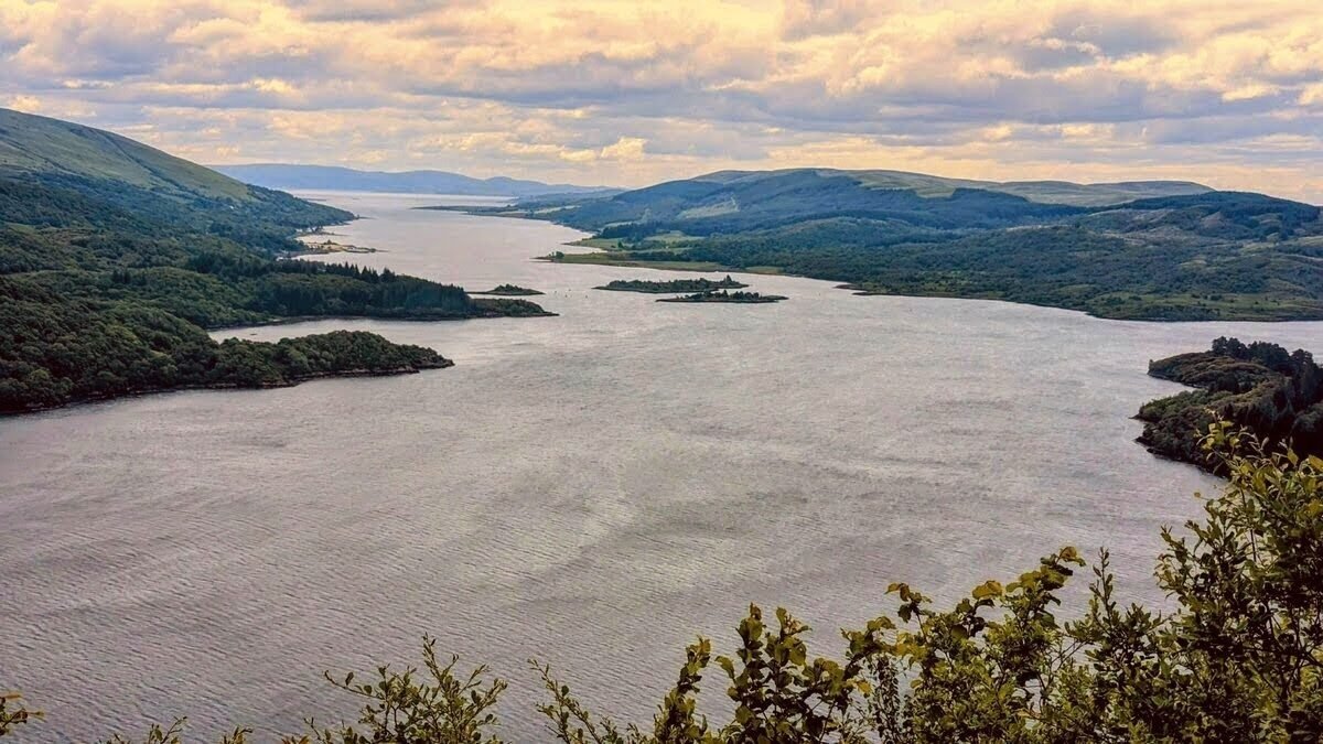 The panoramic view over the Kyles of Bute from the Tighnabruaich Viewpoint — the sea narrows winding between wooded hills and the Isle of Bute.